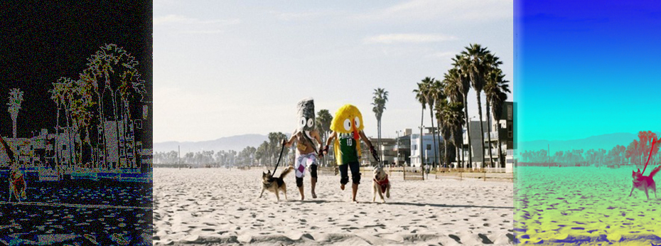 Two figures with giant puppet heads walking their dogs on the beach. Palm trees in background